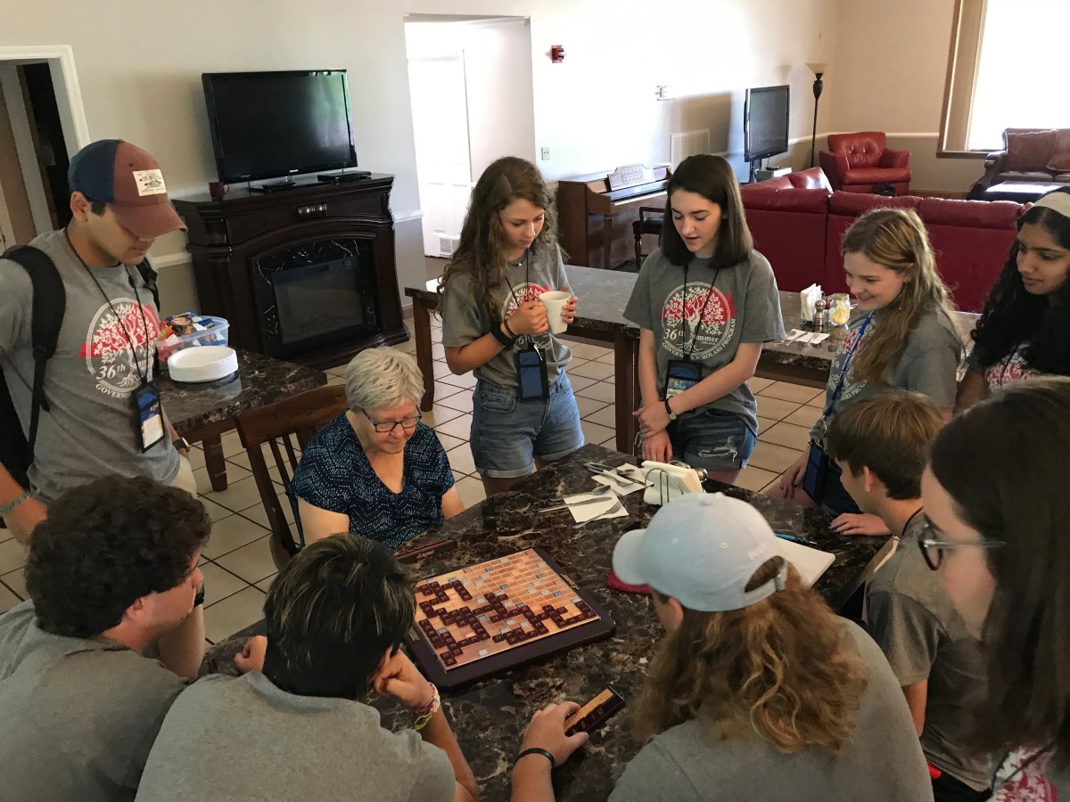 A group of people gathered around a table playing a board game together.