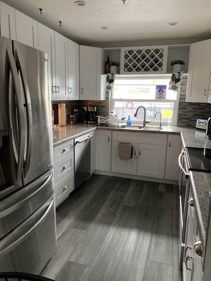 A modern kitchen with stainless steel appliances and white cabinetry.
