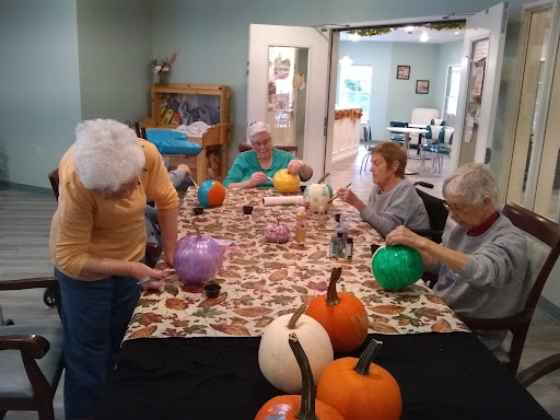 Seniors enjoying a creative pumpkin painting session to celebrate the autumn season.