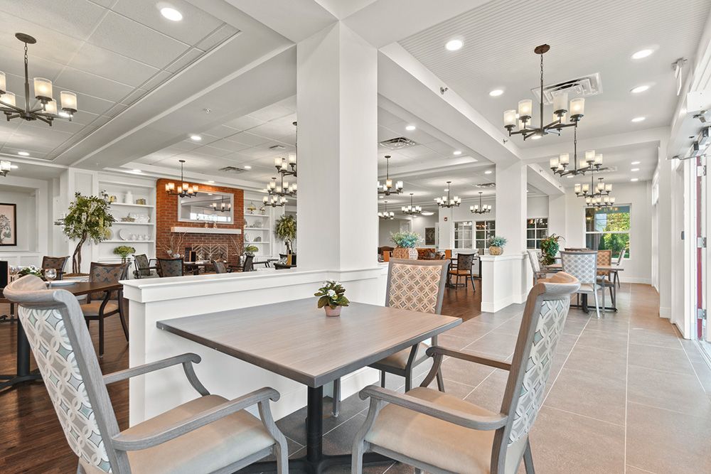 A modern dining area with elegant chandeliers and neatly arranged tables and chairs.