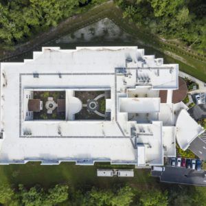 Aerial view of a large building surrounded by trees.