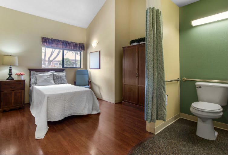 A cozy bedroom with a bed, wardrobe, and wooden flooring.