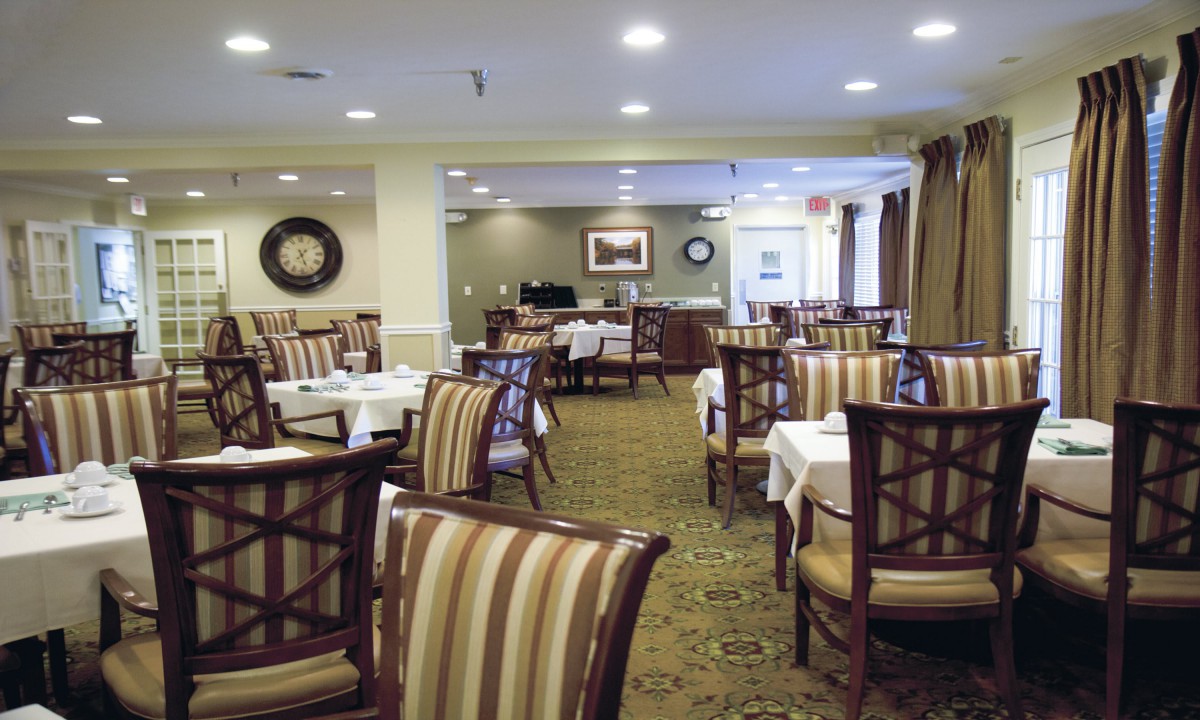 An empty restaurant dining room with neatly arranged tables and chairs.