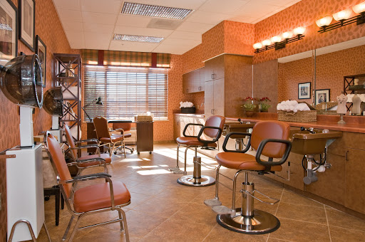 A modern interior of a salon featuring stylish chairs and warm orange tones.