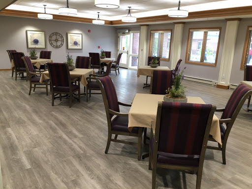 A well-lit dining area featuring tables and chairs arranged for a communal dining experience.