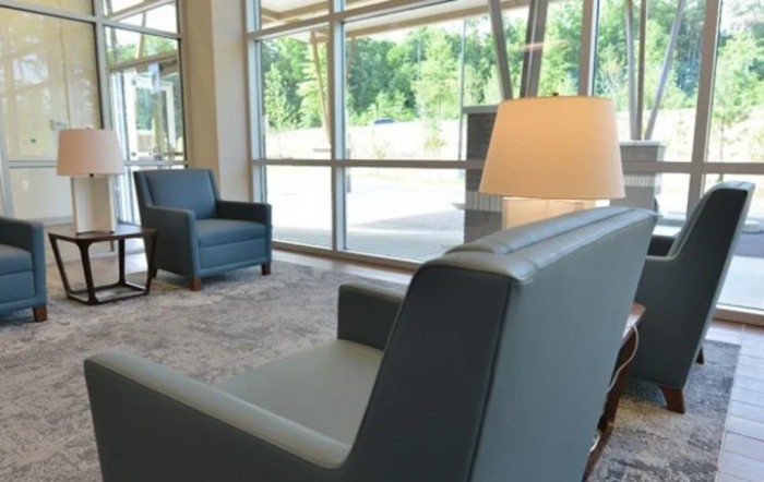 A modern lobby with comfortable seating and large windows providing natural light.