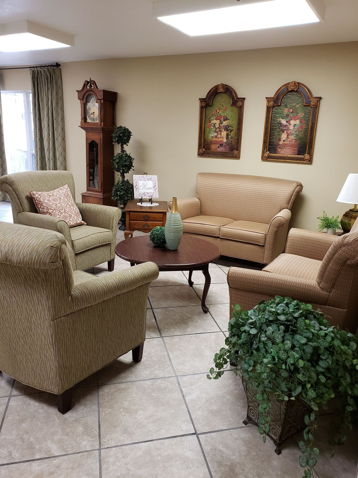 A traditional living room setup with sofas, armchairs, a coffee table, and decorative elements.