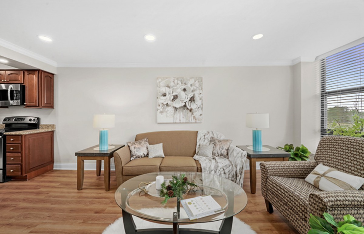 A cozy living room featuring a comfortable sofa, glass coffee table, and modern decor.