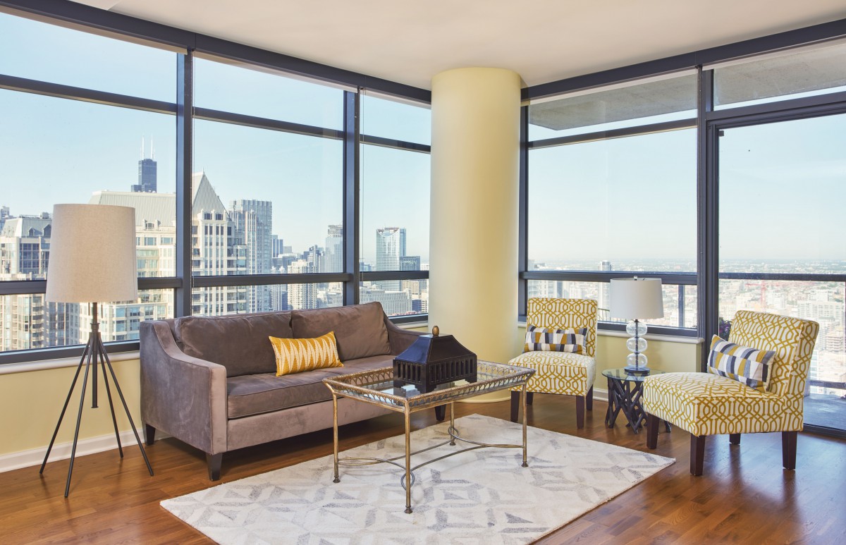 A modern living room with large windows offering a stunning city view.