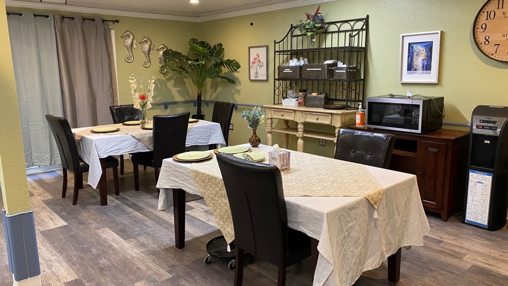A cozy dining area with multiple tables and chairs, adorned with tablecloths and decorations.