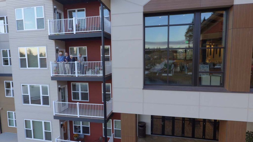 A modern apartment building with multiple balconies and large windows.