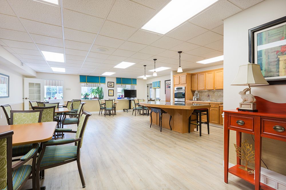 A spacious and modern kitchen with a dining area, featuring wood flooring and ample natural light.