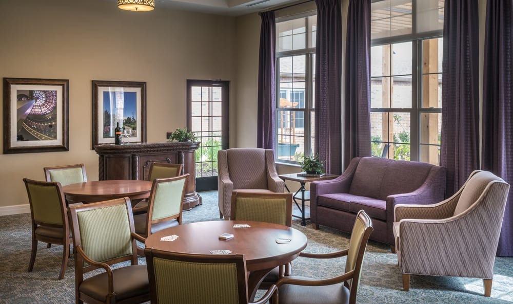 A cozy living room with multiple seating areas and large windows.