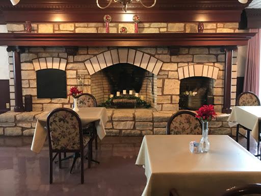 An inviting restaurant interior featuring charming tables and a cozy fireplace.