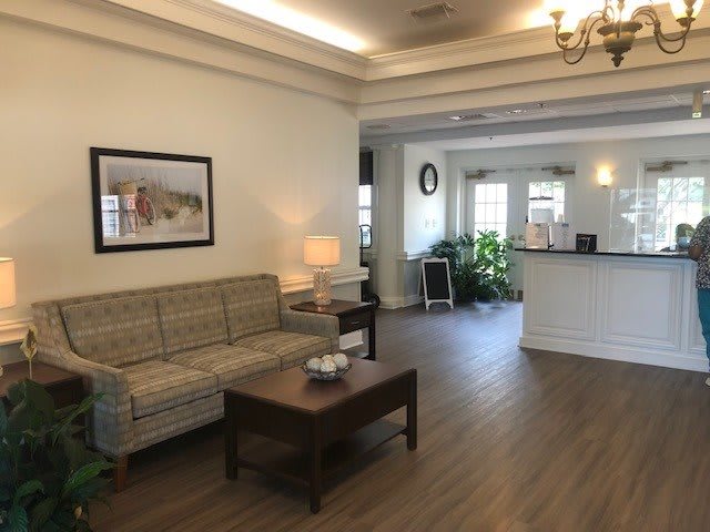 A cozy living room with a sofa, coffee table, and elegant decor near a reception area.