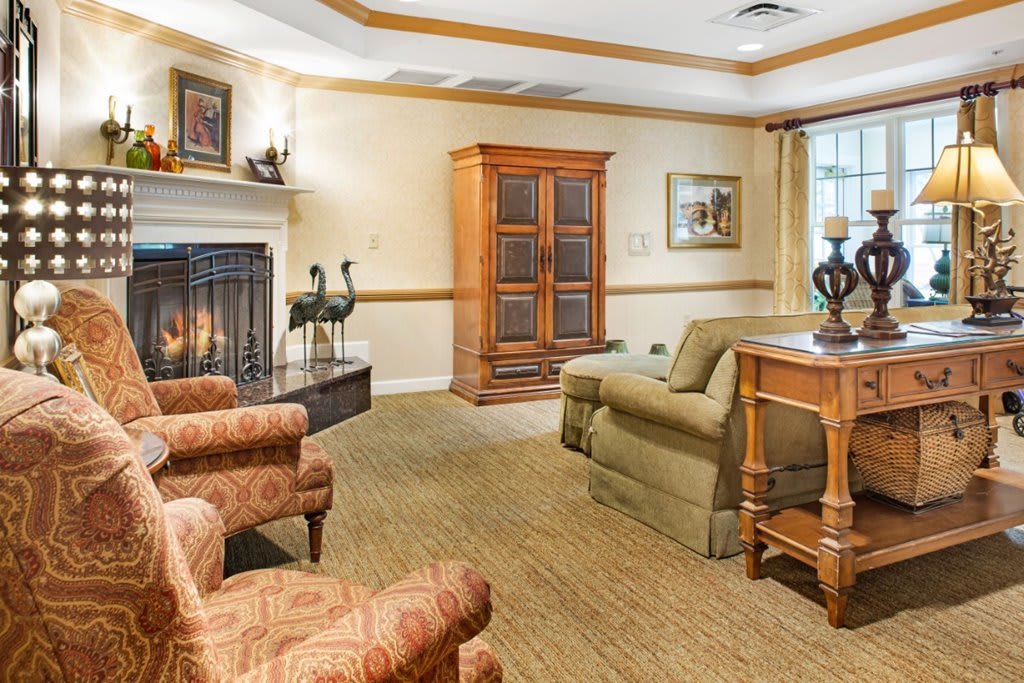 A cozy living room with a fireplace, comfortable seating, and elegant decor.