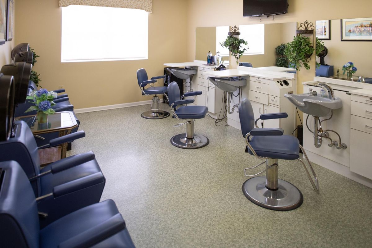 A modern barber shop interior with several empty chairs and mirrors.