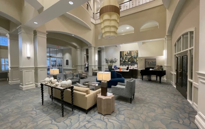 A spacious and elegantly decorated lobby with comfortable seating and a grand chandelier.