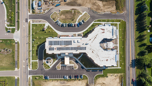 An aerial view of a modern building surrounded by organized parking areas and landscaped grounds.