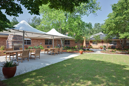 A serene outdoor space featuring a landscaped garden, seating arrangements, and stylish canopies.