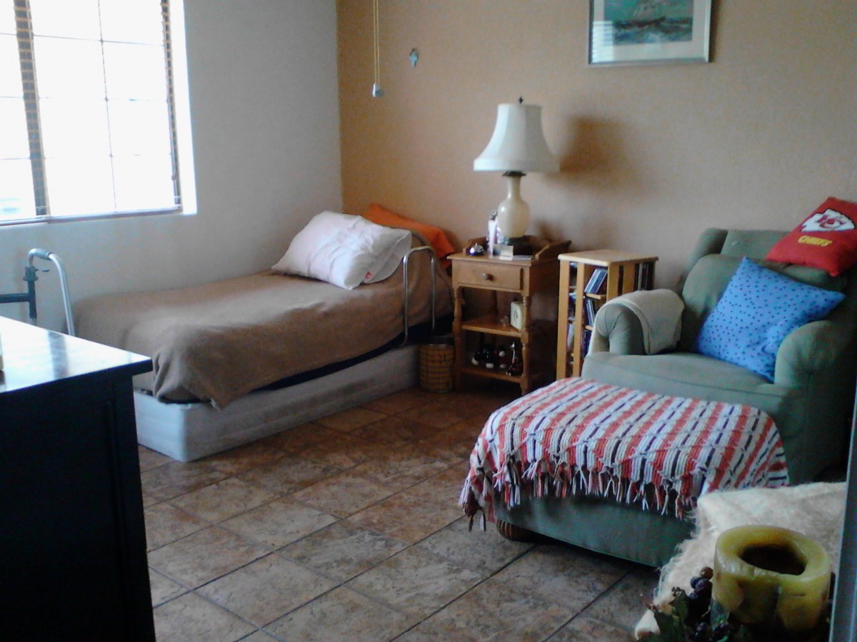 A cozy bedroom with a single bed and an armchair.