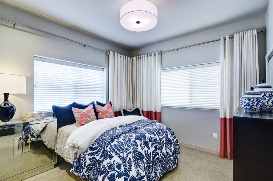 A cozy modern bedroom with stylish bedding and curtains.