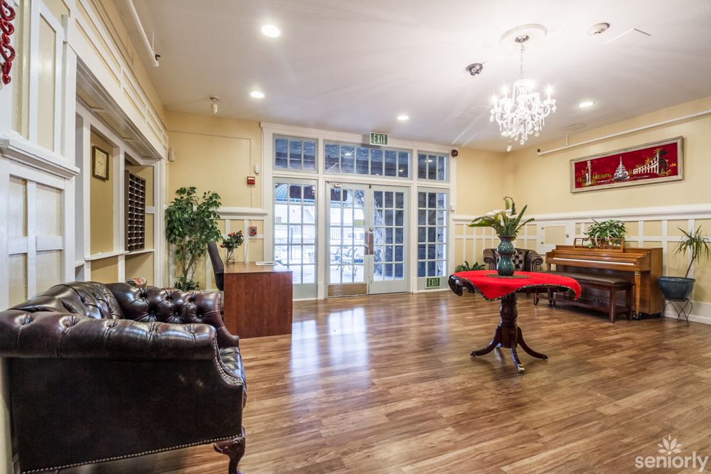 Elegant lobby area with a chandelier and wooden flooring.