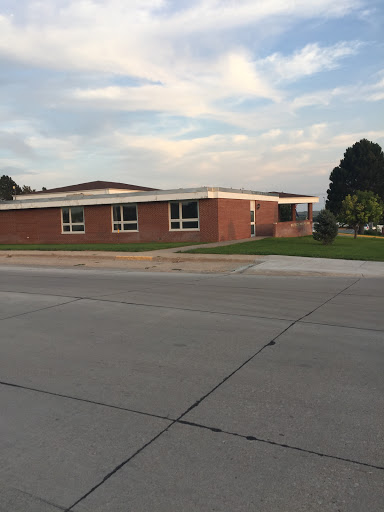 A brick school building set against a cloudy sky.