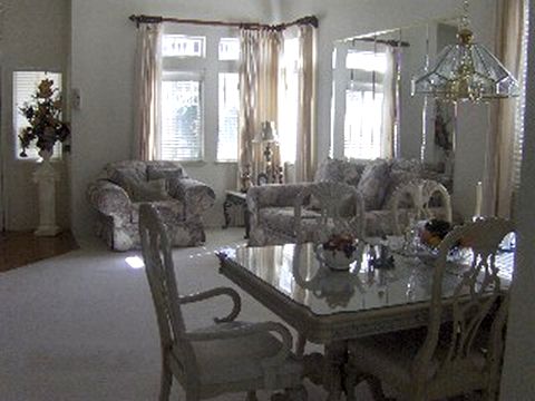 A cozy living room and dining area with elegant furnishings and large windows.