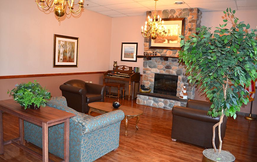 A cozy living room with a stone fireplace, comfortable seating, and elegant decor.