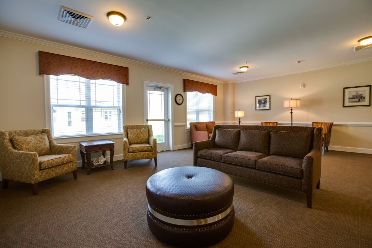 A cozy living room with a sofa, chairs, and soft lighting.