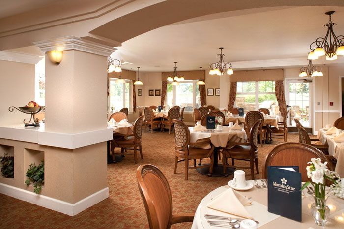 An elegant dining room setup with neatly arranged tables and chairs.