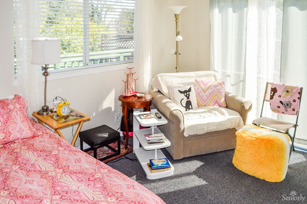 A cozy living room corner with a comfortable chair, side tables, and a standing lamp.