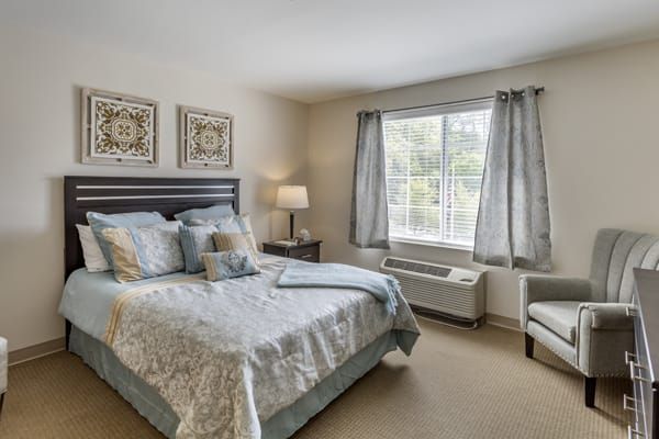 A cozy bedroom with a neatly made bed, soft lighting, and elegant decor.