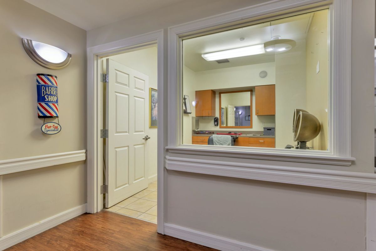 A view of a professional office hallway with a reception window and doorway.
