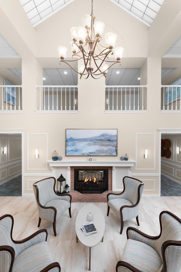 Luxurious and modern living room featuring a grand chandelier, elegant fireplace, and comfortable seating.