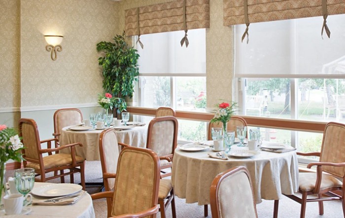 An elegantly decorated restaurant dining room with neatly arranged tables and chairs.