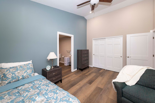 A cozy and modern bedroom featuring a calming blue accent wall and stylish furniture.