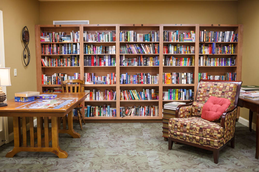 A cozy library space with bookshelves filled with books and comfortable seating.