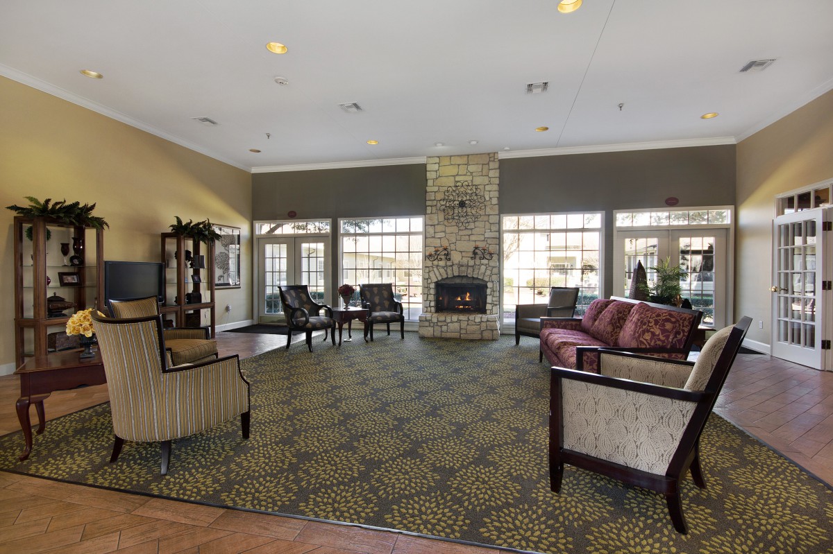 A spacious living room with a fireplace, ample seating, and large windows providing natural light.