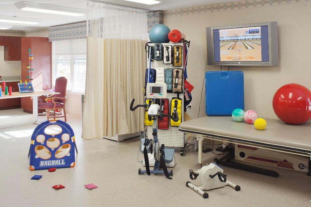 A well-equipped physical therapy room with various exercise equipment and rehabilitation tools.