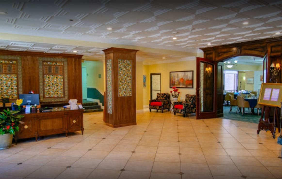 A spacious hotel lobby featuring elegant wooden decor and comfortable seating.
