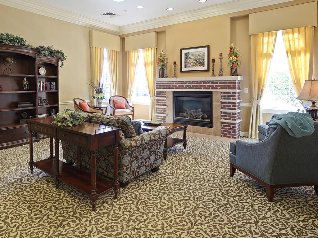 A cozy living room with a traditional design, featuring a fireplace and elegant furnishings.