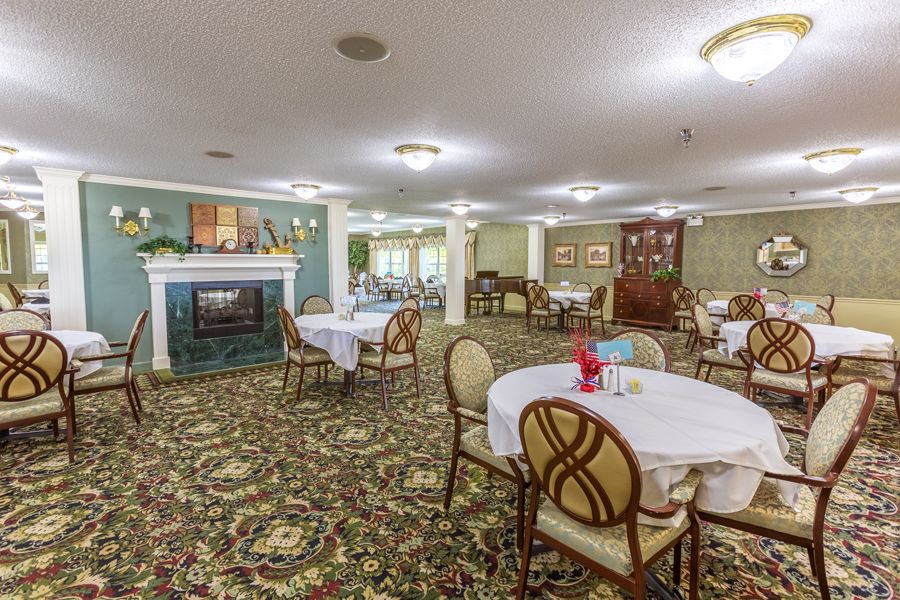 Spacious dining area with round tables and a fireplace.