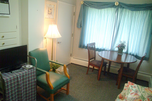 A cozy living room setup featuring a green chair, a wooden table, and soft lighting.