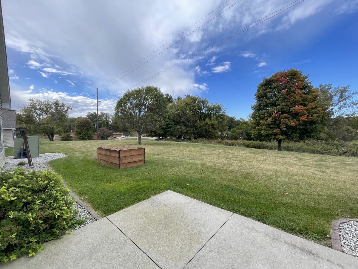 A scenic park view with trees and a partly cloudy sky.