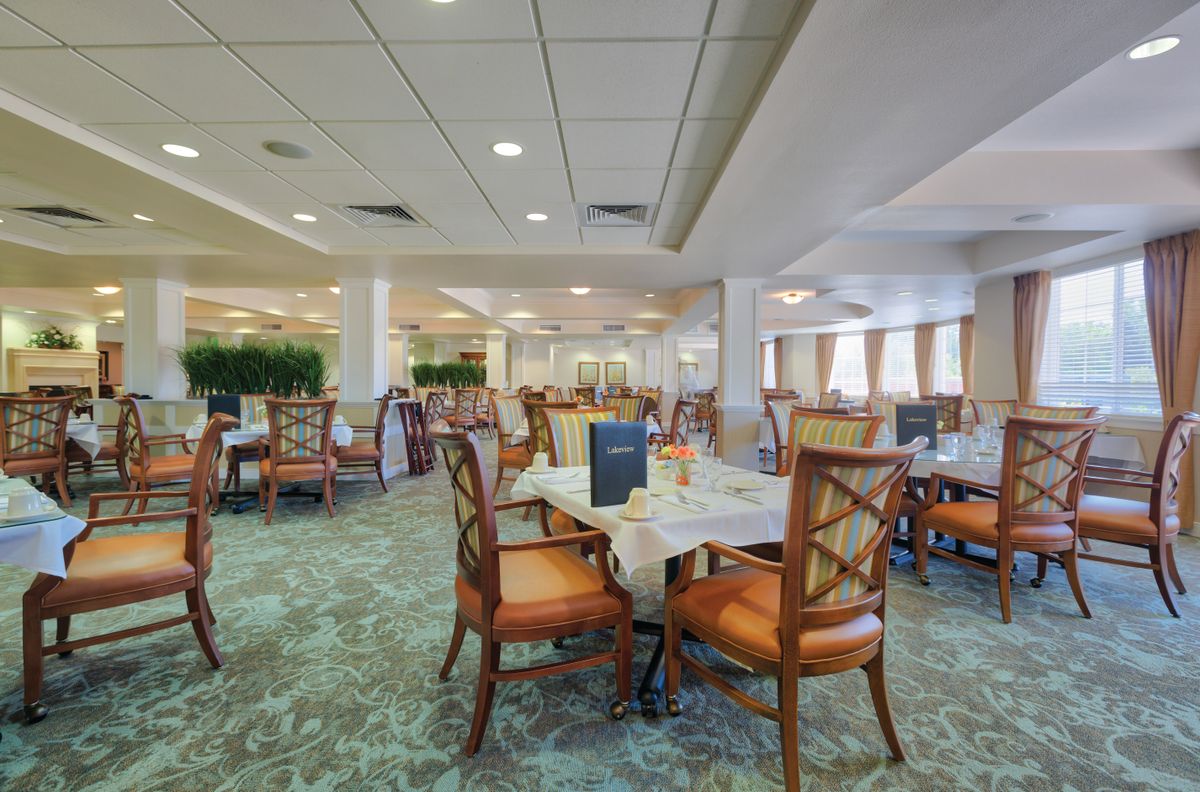 An empty restaurant dining area with neatly arranged tables and chairs.