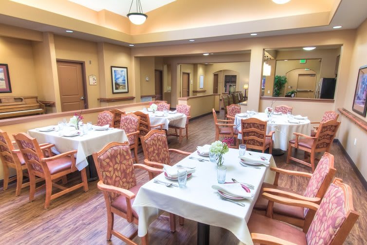 A spacious dining area with neatly arranged tables and chairs set for a meal.