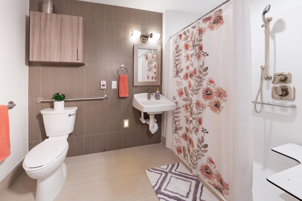 A modern bathroom with a floral-patterned shower curtain and stylish decor.