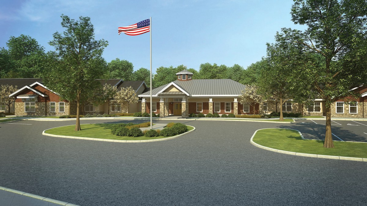 A building with a driveway and an American flag in front.